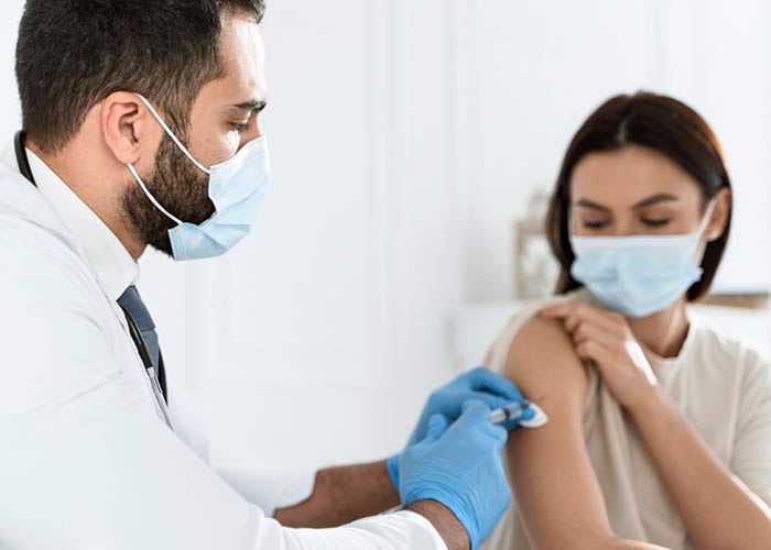 Vaccinated Outside Qatar: How To Get Quarantine Exemption Doctor Vaccinating Young Woman
