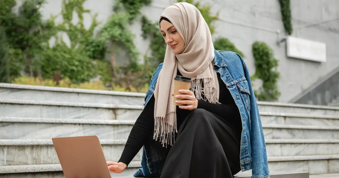 Modern Muslim woman using laptop - Featured image for immigration lawyer in Qatar